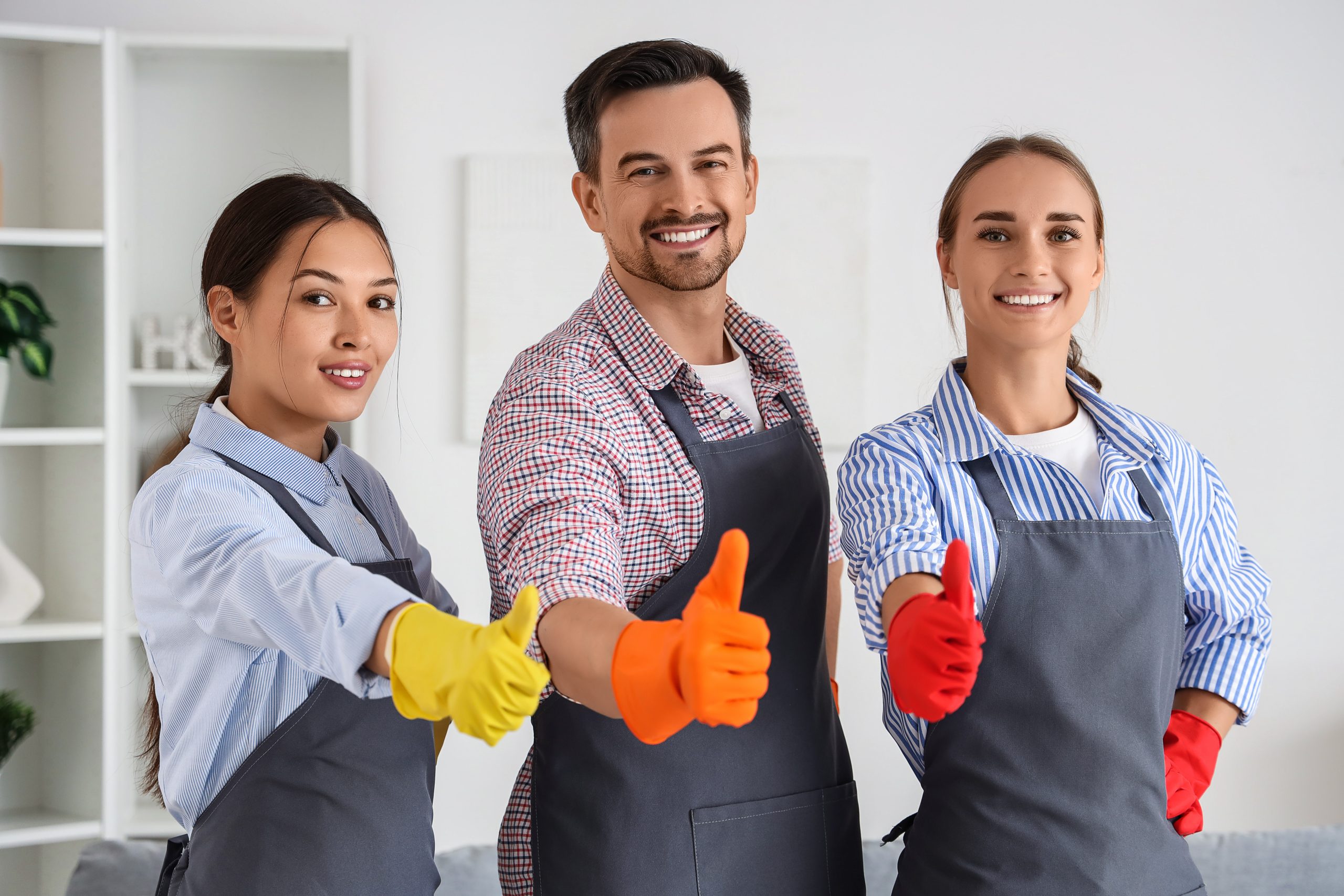 Professional cleaning service team, diverse cleaners giving thumbs up for quality home maintenance and housekeeping satisfaction in a bright interior