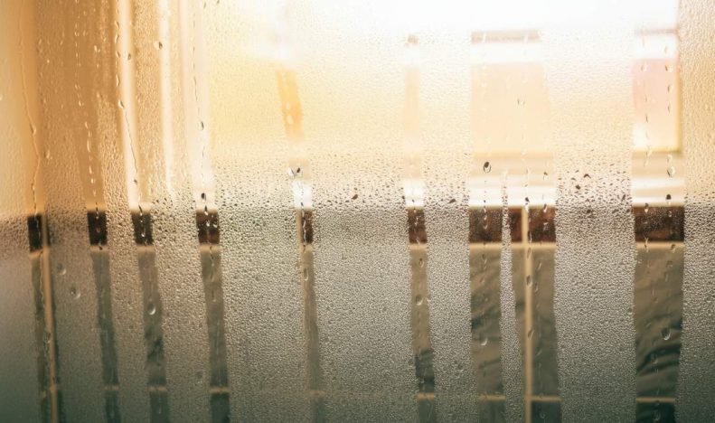 Foggy glass window with condensation and water droplets