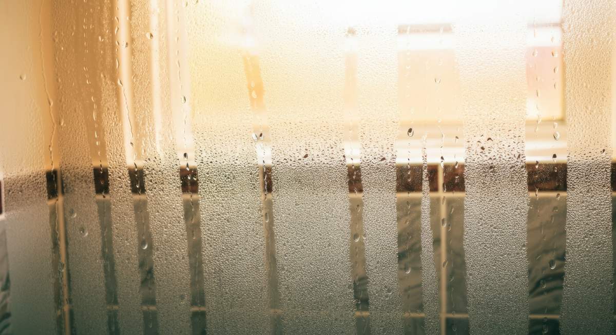 Foggy glass window with condensation and water droplets